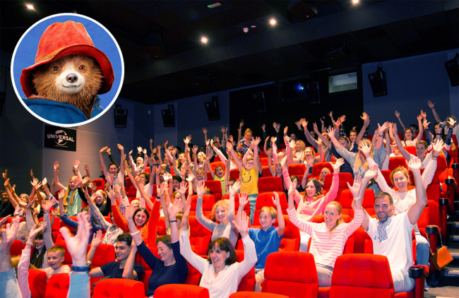 people sitting in cinema with arms up in excitement