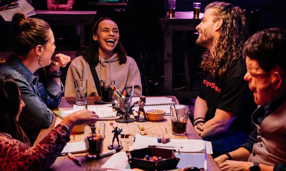 people sat around a dungeons and dragons table laughing